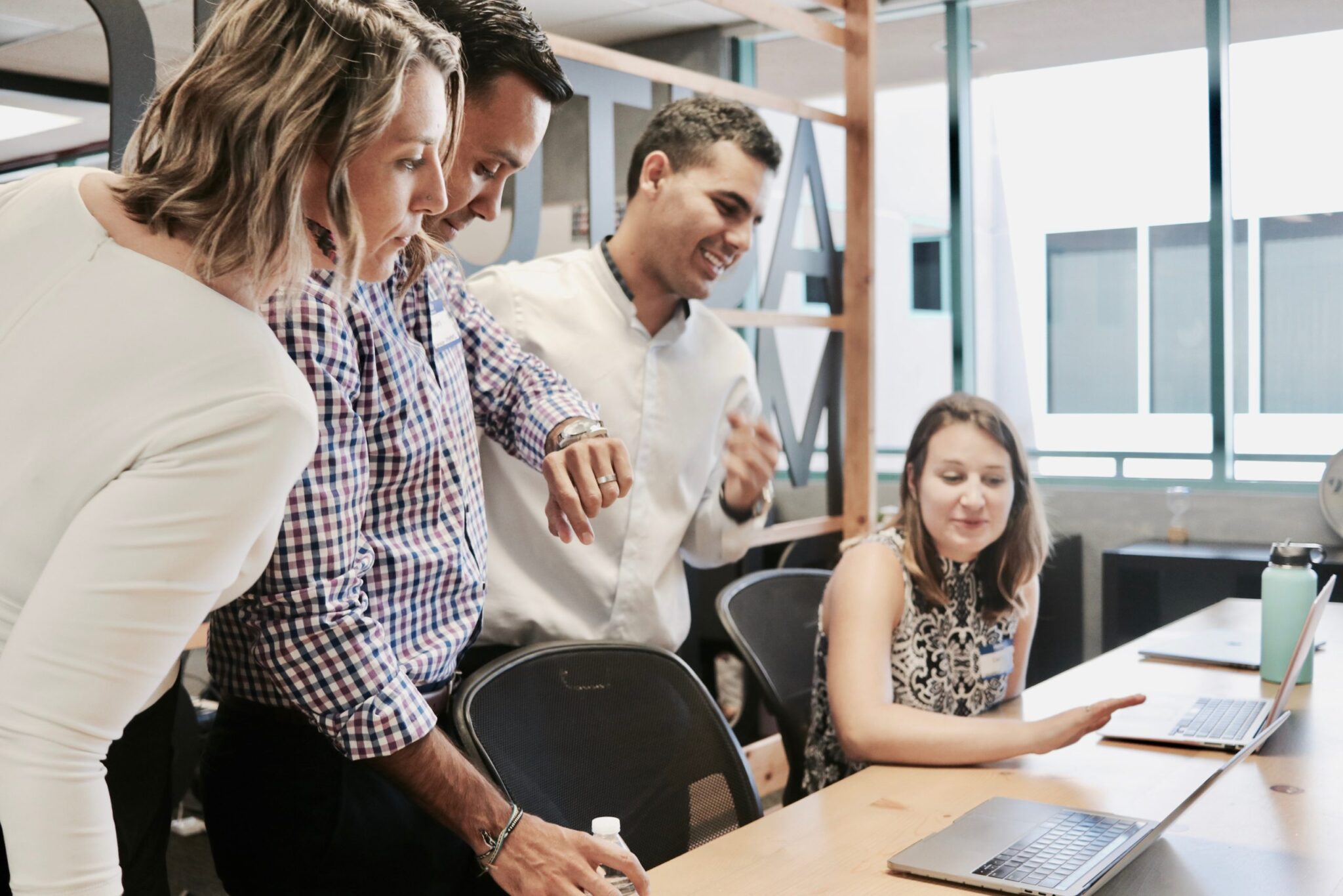 Image of people crowding around a conference table from Electronic Design Company