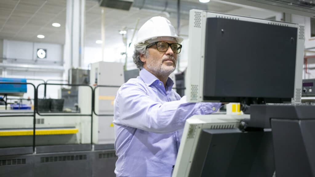 man wearing a hardhat on a computer